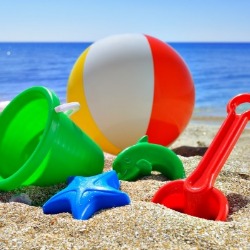 beach ball, shovel, and toys on the beach | Island Real Estate