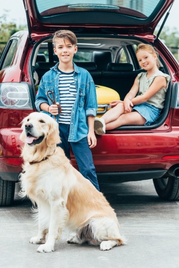children and dog with packed car | Island Real Estate