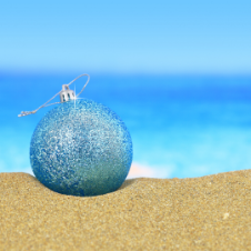 blue holiday ornament in the sand 