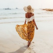 woman walking on the beach in a long skirt | Island Real Estate