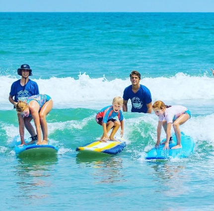 students surfing at Surf City Surf School | Island Real Estate