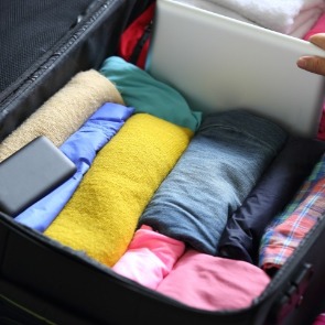 clothing rolled up in a suitcase | Island Real Estate