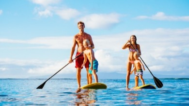 family paddle boarding on topsail beach | Island Real Estate